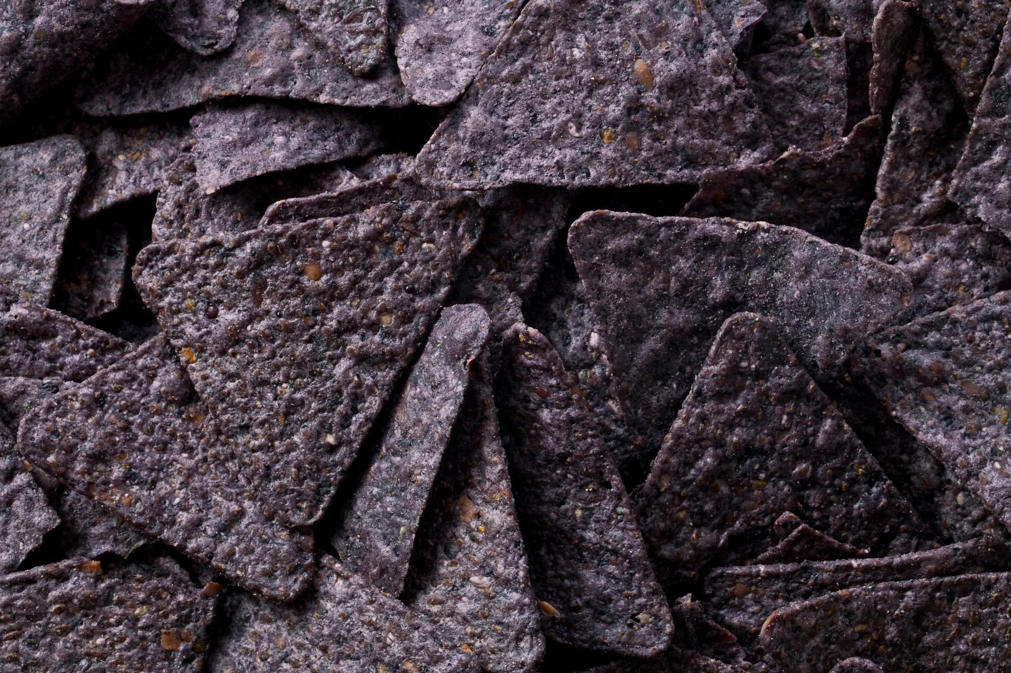Close up image of heap of blue nachos 