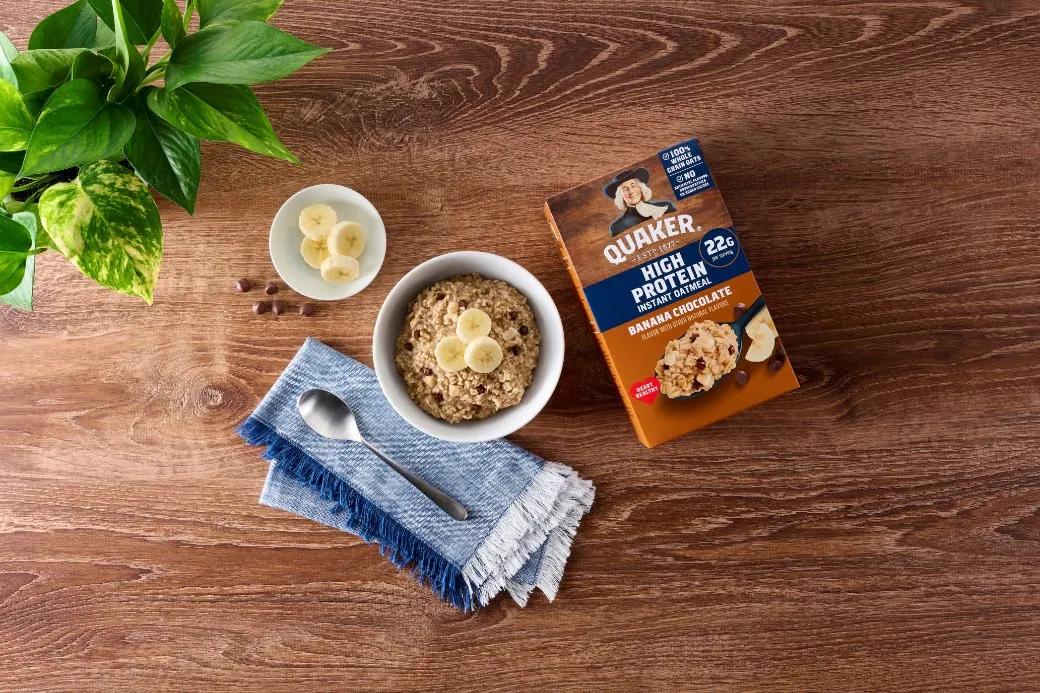 A bowl of oatmeal with bananas and a box of cereal